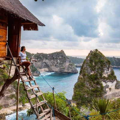Woman at treehouse, Nusa Penida, Bali, Indonesia Woman near tree house, Nusa Penida, Bali, Indonesia